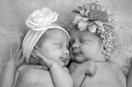 Black and White photo of 2 babies with cute hats